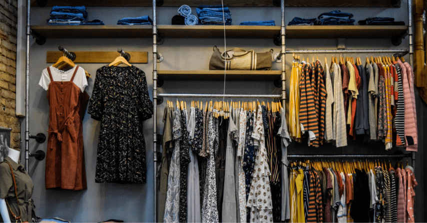 A wardrobe with a lot of colorful and different designed clothes.